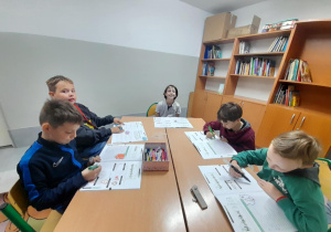 Dzieci na zajęciach TUS pracują rozwiązując zadania w ćwiczeniach z programu profilaktyczno - psychologicznego.