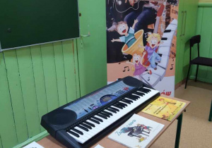 Na ławce szkolnej leży keyboard i podręczniki z nutami.