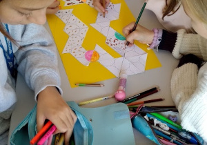 Trzy uczennice z klasy 6b współpracują przy tworzeniu parkietażu.