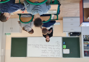 Uczennica klasy 8a czyta młodszym dzieciom fragment książki A. Lindgren „Dzieci z Bullerbyn”.