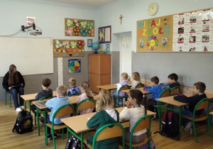 Uczennica klasy 8a czyta bajkę uczniom z klasy 1a.