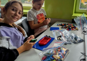 Dziewczynki z klasy 4B wspólnie pozujące do zdjęcia podczas układania klocków LEGO.