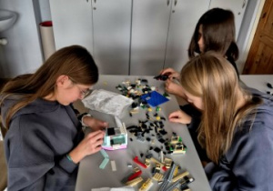 Uczniowie klasy 7C usiedli dookoła jednego stolika, by wymieniać się klockami LEGO.