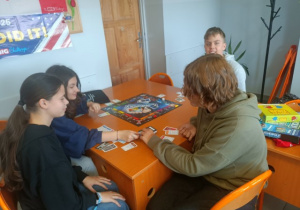 Czworo uczniów z klasy 7a grają w grę Monopol.
