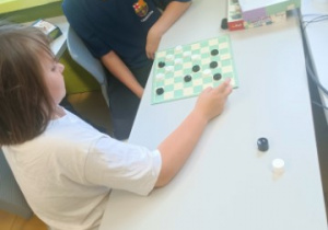 Dwaj uczniowie z klasy 4a grający w warcaby.