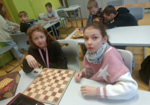 Dwie uczennice z klasy 4 a grają wwarcaby.