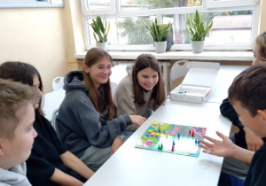 Uczniowie i uczennice z klasy 7c grają w chińczyka.