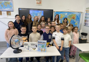 Uczniowie z klasy 2C wraz z wychowawcą pokazują jakie upominki otrzymały od firm Educarium i Moje Bambino..