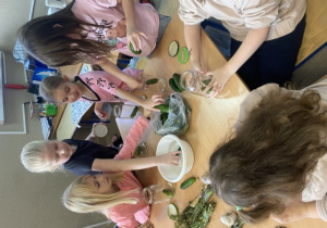 Uczennice klasy 2 c myją ogórki i wkładają je do słoików.