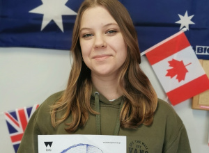 Lena z klasy 8 A pozuje z plakatem promującym festiwal Wood Design.