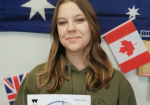 Lena z klasy 8 A pozuje z plakatem promującym festiwal Wood Design.