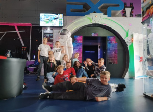 Uczniowie klasy 4b ustawieni do zdjęcia grupowego pod wejściem do Eksperymentarium.