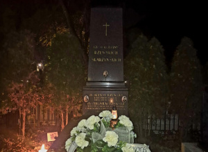 Wieniec z białych kwiatków z szarfą z napisem: “Dziękujemy - społeczność SP nr 116 w Łodzi”, leżący na grobie Aleksego Rżewskiego.