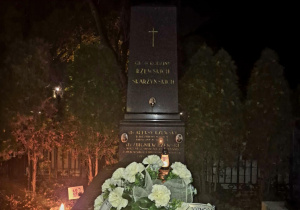 Wieniec z białych kwiatków z szarfą z napisem: “Dziękujemy - społeczność SP nr 116 w Łodzi”, leżący na grobie Aleksego Rżewskiego.