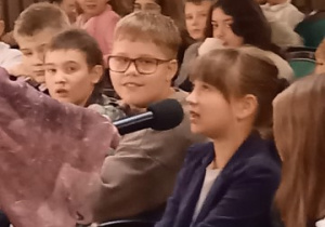 Uczennica odpowiada na pytanie przez mikrofon.