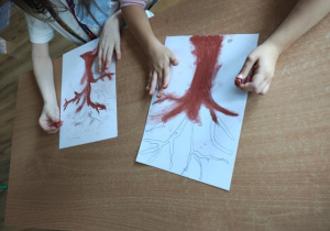 Uczennice rysują drzewa przy użyciu suchych pasteli.