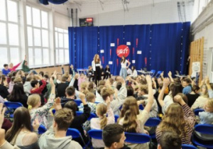 Publiczność z podniesionymi rękoma, podczas odpowiedzi, kto w naszej szkole będzie walczył z hejtem.