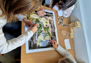 Trzy uczennice malują obraz zgodnie z numeracją koloró..