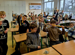 Cała klasa 5a pozująca do zdjęcia ze swoimi makramami.