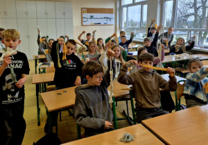 Cała klasa 5a pozująca do zdjęcia ze swoimi makramami.
