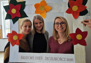 Pani Beata, pani Oliwia oraz pani Ewelina pozujące do zdjęcia w ramce na korytarzu szkolnym.