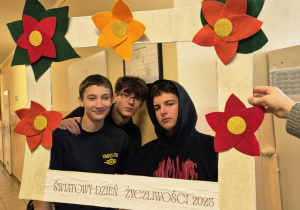 Wspólne zdjęcie trzech chłopców z klasy 8B w ramce z napisem “Światowy Dzień Życzliwości 2025”