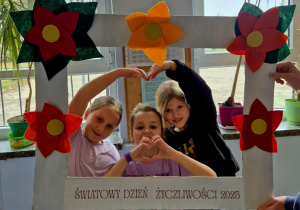 Trzy dziewczynki z klasy 2A tworzące serduszko z rąk.