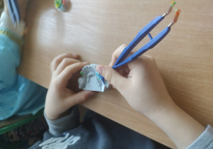 Uczennica w czasie wypełniania plasteliną znalezionych ubytków.