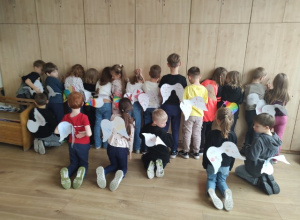 Uczniowie pozują tyłem i prezentują swoje „skrzydła odwagi”.