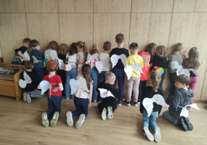 Uczniowie pozują tyłem i prezentują swoje „skrzydła odwagi”.