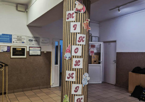 Baner “Mikołajki” zawieszony na słupie przy głównym wejściu do szkoły.