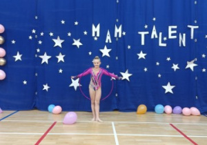 Uczennica klasy 3 prezentuje swój talent akrobatyczny w pokazie z hula-hop.