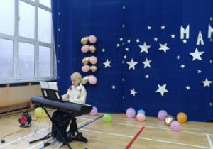 Uczennica klasy 3. gra na pianinie prezentując swój talent muzyczny.