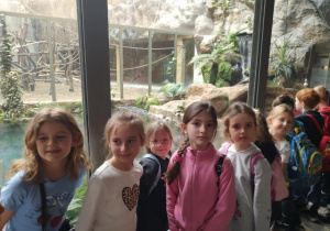 Kilkoro uczniów klasy 1b pozuje przy klatce z krokodylami.