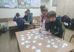 Uczniowie z rodzicami grają w gry wspierające naukę czytania i pisania.