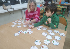 Chłopiec z mamą dopasowują elementy sześciennej układanki.