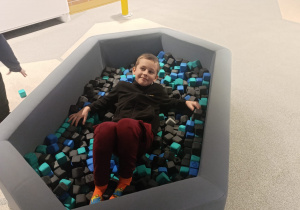 Chłopiec w basenie z piłkami.