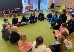 Warsztaty – dzieci siedzą na dywanie w kole i poznają wzajemnie swoje zmysły .