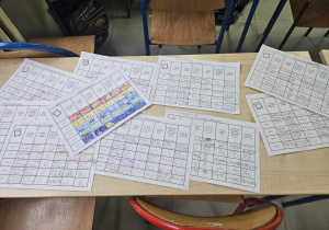 Kolorowe Dzienniki Wdzięczności rozsypane na ławce.