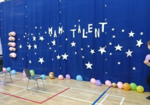 Dekoracja przygotowana na uroczystość rozstrzygnięcia konkursu umieszczona na granatowym tle.