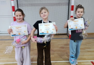Uczennice klasy 2 prezentują dyplomy i nagrody.