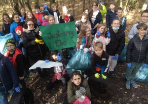 Uczniowie zbierają śmieci do plastikowych worków