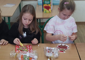Dwie uczennice ozdabiają pierniki.