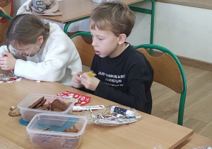 Dwoje uczniów dekoruje pierniki.