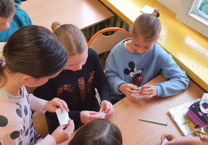 Uczniowie składają papier techniką origami