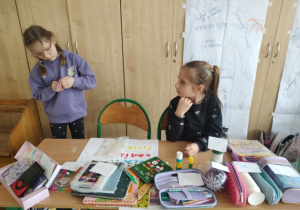 Uczennice klasy 1b szykują wystawę sklepiku papierniczego.