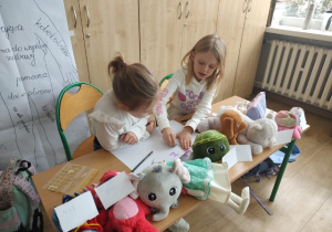 Uczennice klasy 1b szykują wystawę sklepiku z pluszakami.