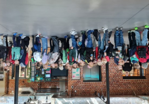 Dzieci stoją w holu teatru i czekają w kolejce do szatni.