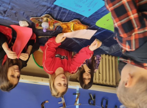 Dzieci stoją przy stacjach z wróżbami.