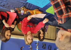 Dzieci stoją przy stacjach z wróżbami.